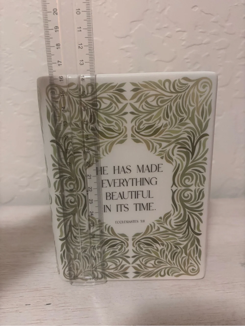 ceramic book vase with green floral swirls and the words…